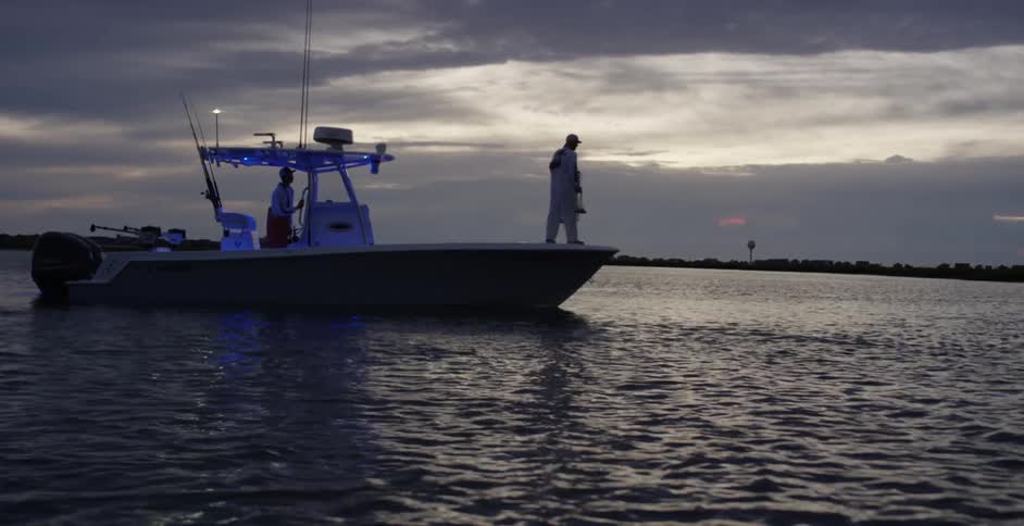 Two men on a boat on a lake at dusk