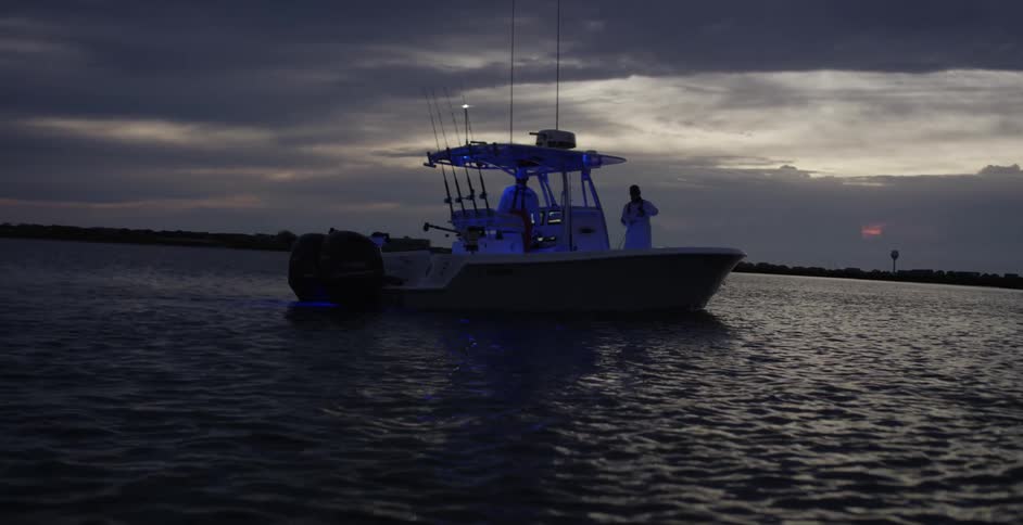 Two people are driving a boat on the ocean water
