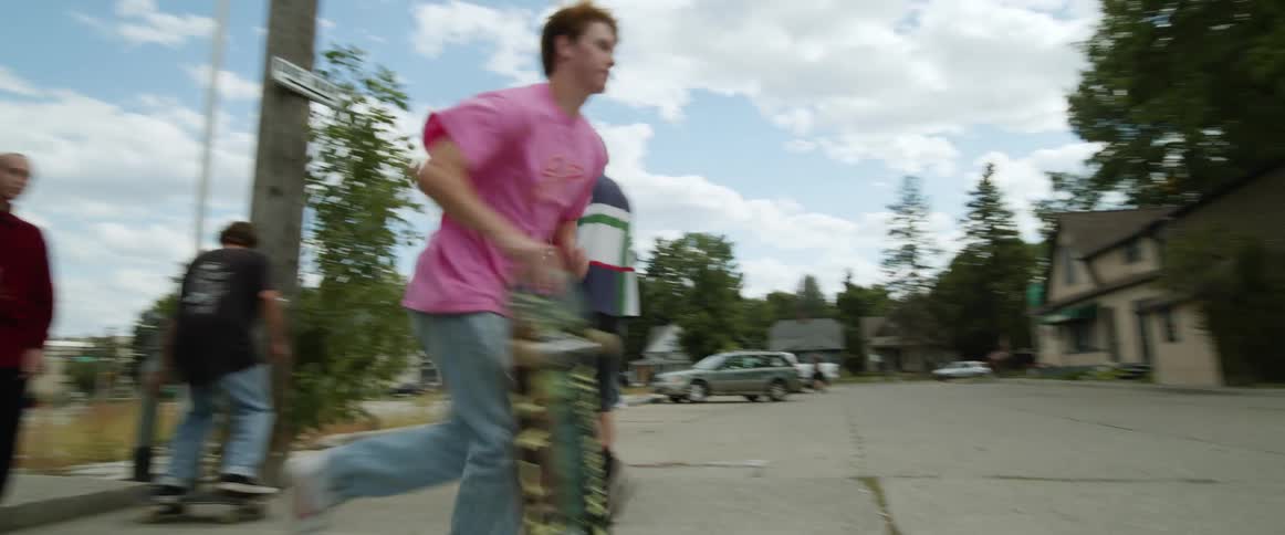 Group of young friends skateboarding on the sidewalk of a small town