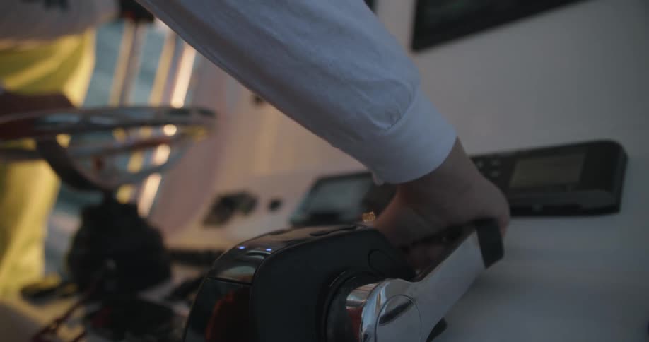 Hands controlling the wheel and driving a boat