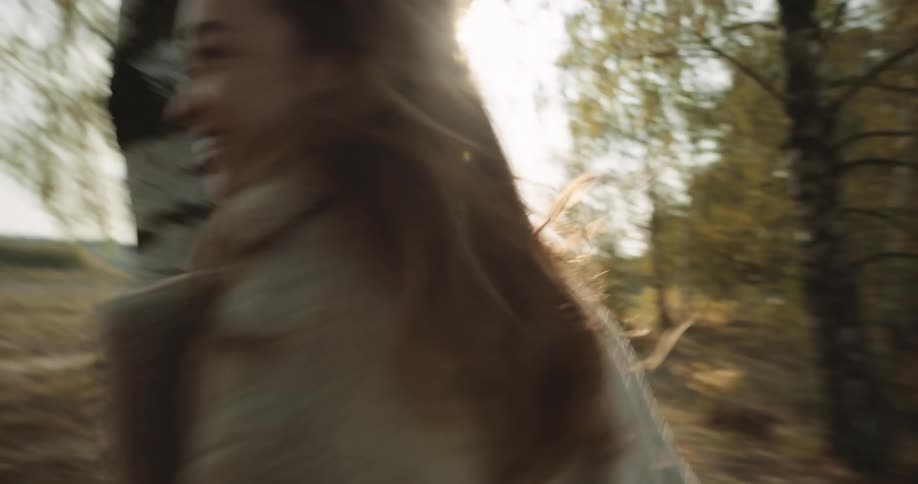 Male and female are running through a forest together
