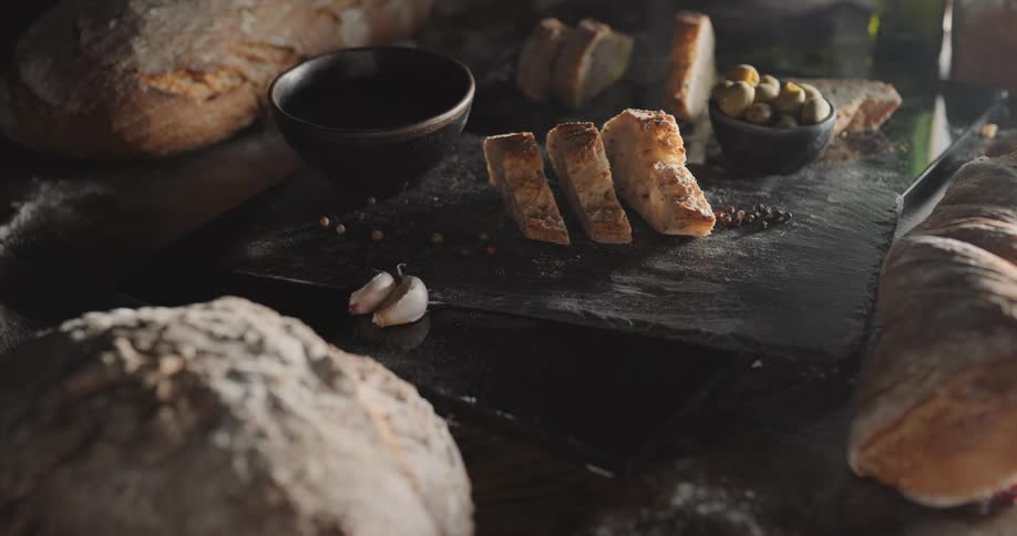 Slices and loaves of freshly baked bread resting over a table