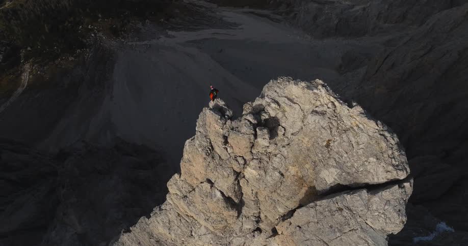 A person is rock climbing up a mountain during the day time