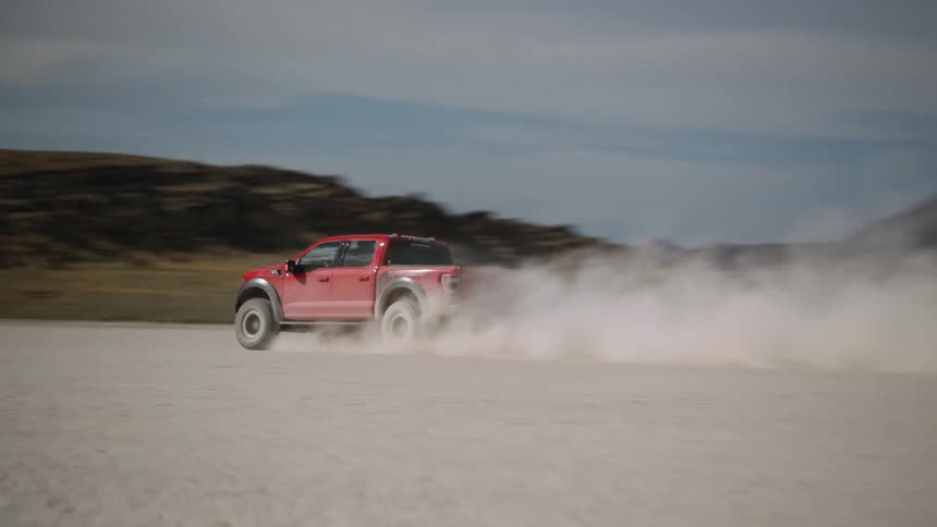 A red truck spinning cookies and speeding over a dirt field