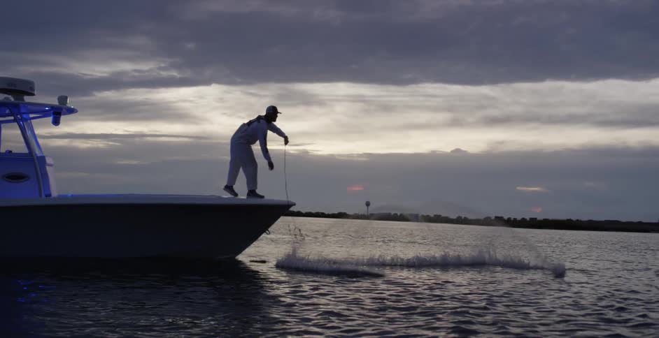 Fisherman casts nest from boat on the ocean