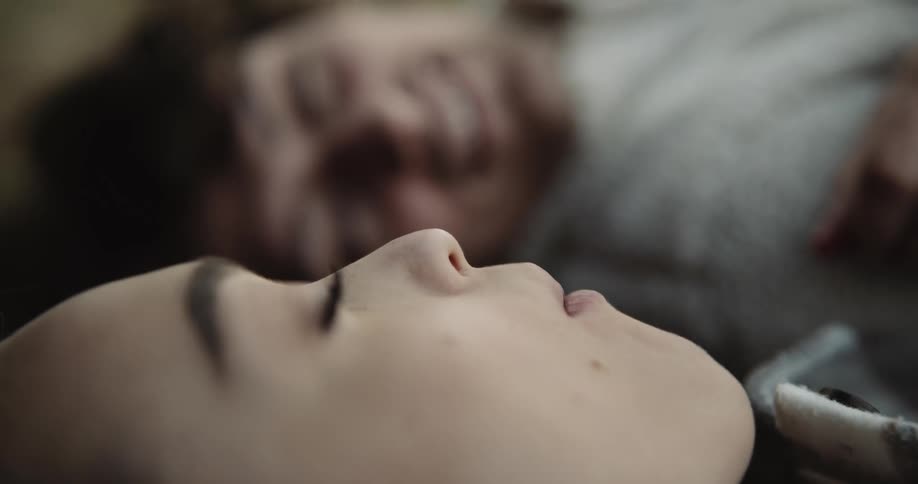 Young happy man laying in the forest ground feeds berries to her girlfriend