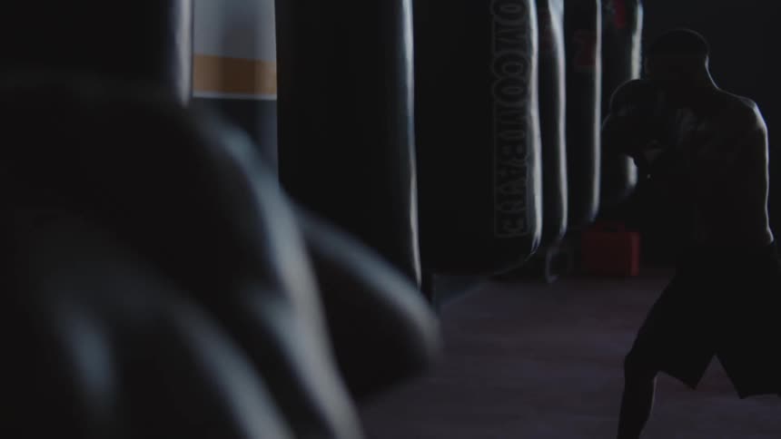 Two men are boxing in a gym together