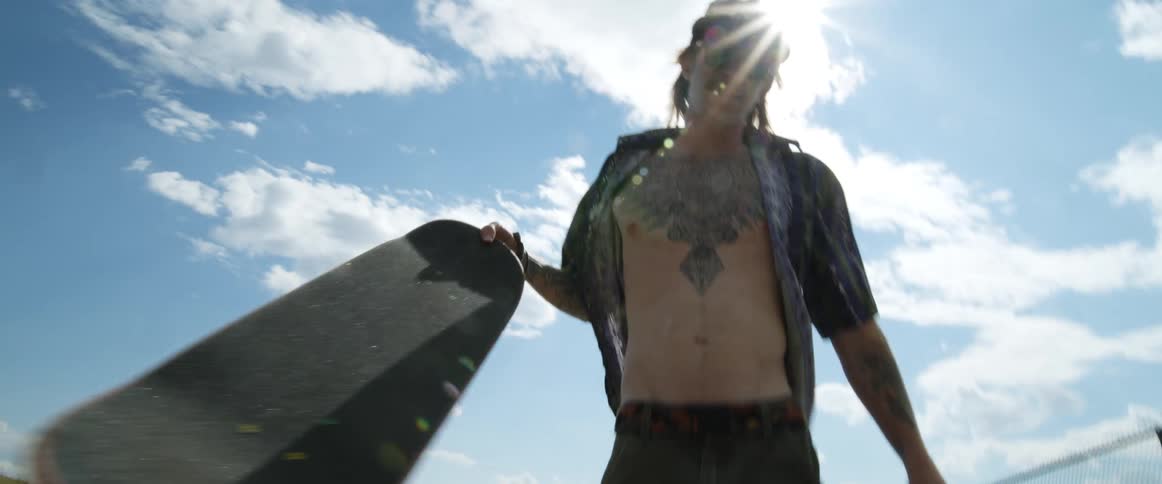 A man picks up his skateboard