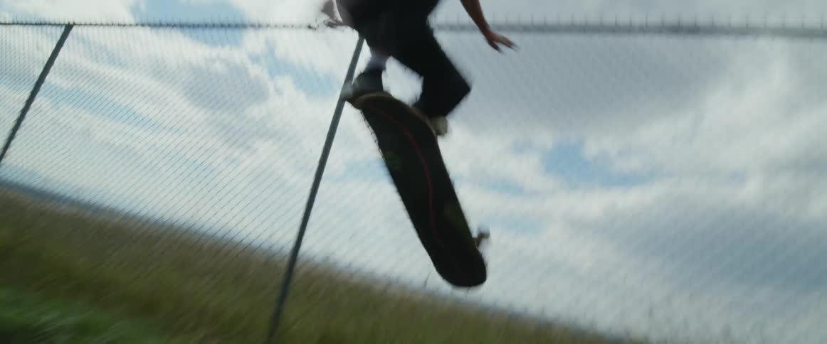 A young teenage boy is skate boarding outside in the day time