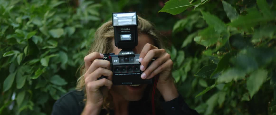 A blond man photographing frontally with his camera