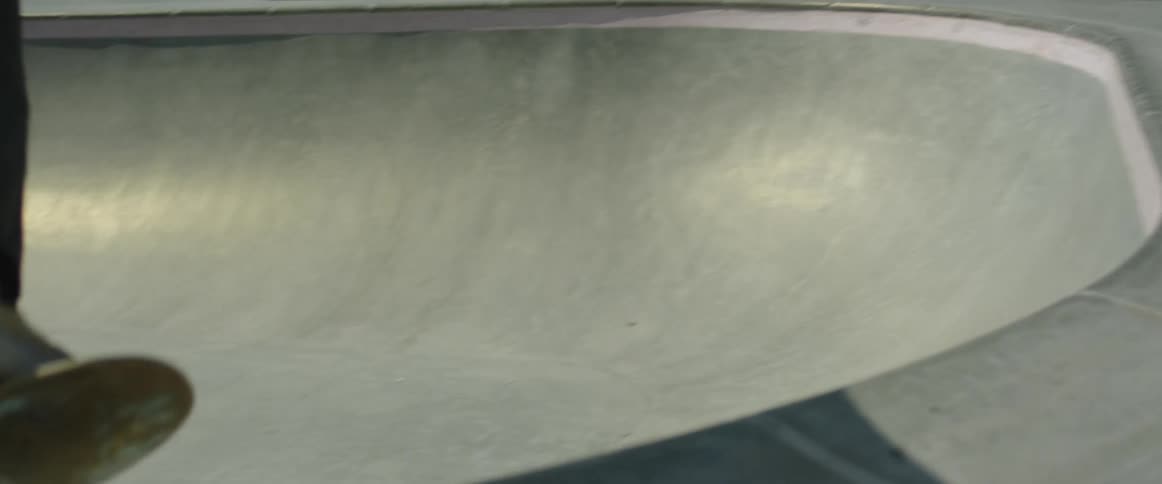 A young white teenager is skateboard outside in the day time
