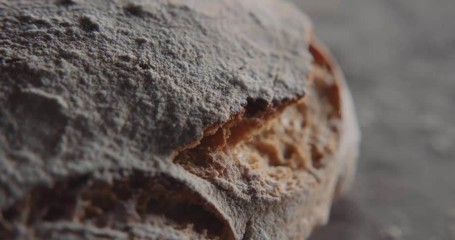 Seasoning is sprinkling down on a loaf of fresh baked bread