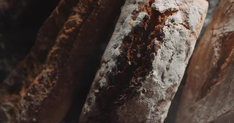 Flour being slowly poured on a loaf of bread