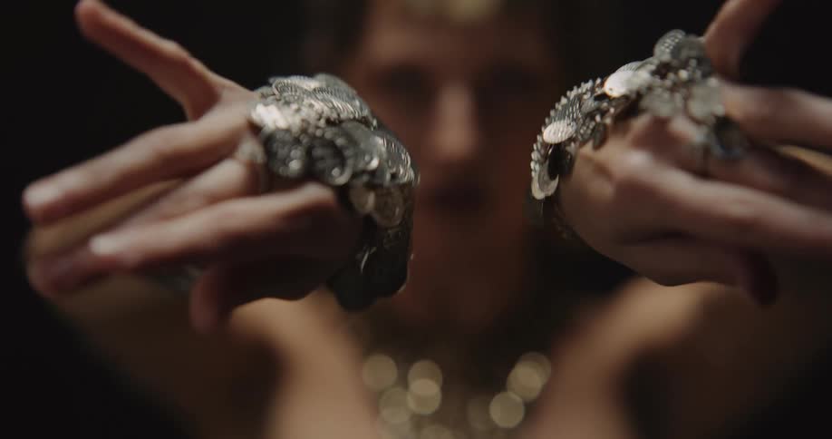 A womans hands in focus slowly moving with jewelry on her hands and wrists