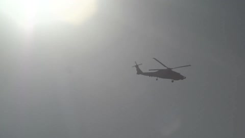 A helicopter is flying in a cloudy sky