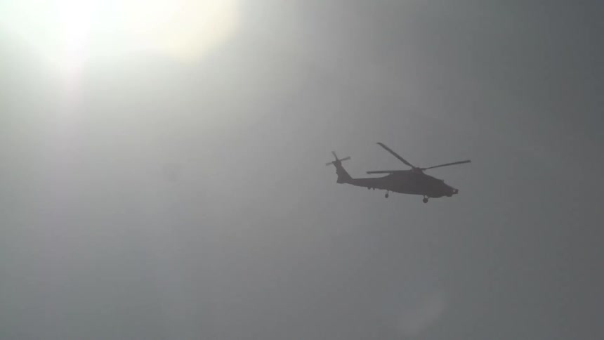A helicopter is flying in a cloudy sky