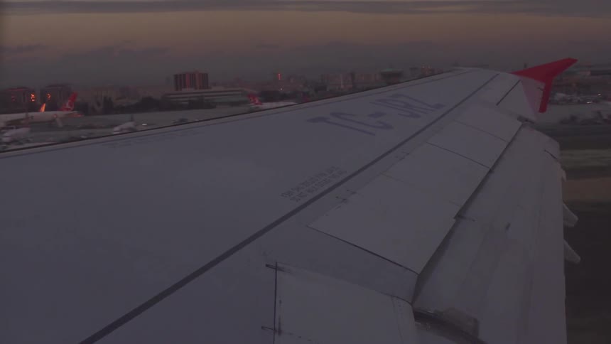 A plane is taking off from a runway at dawn