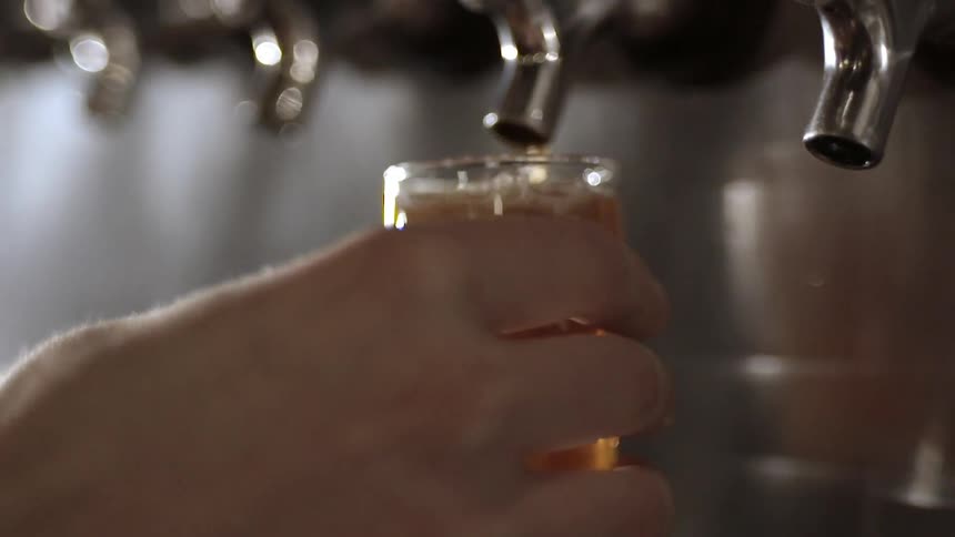 A person fills a small glass