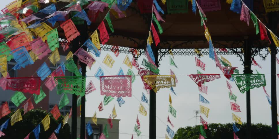 Banners strung onto lines decorate open air pavilion while fluttering in the breeze