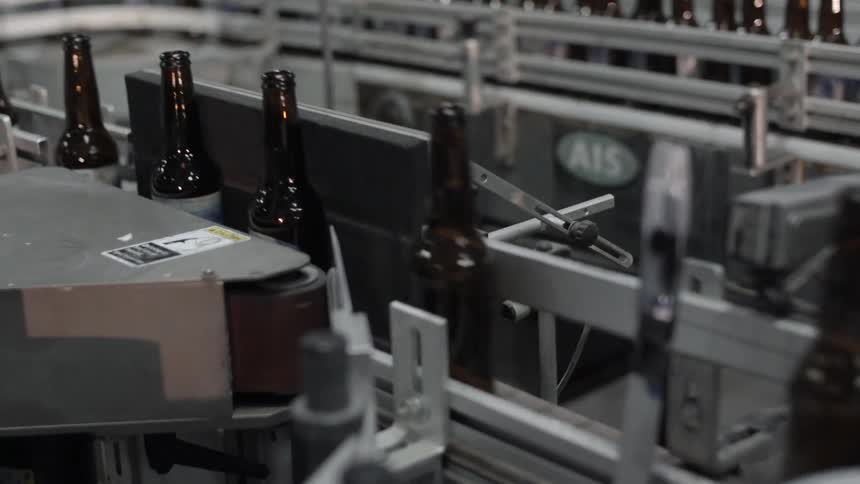 Brown glass bottles on a conveyor belt