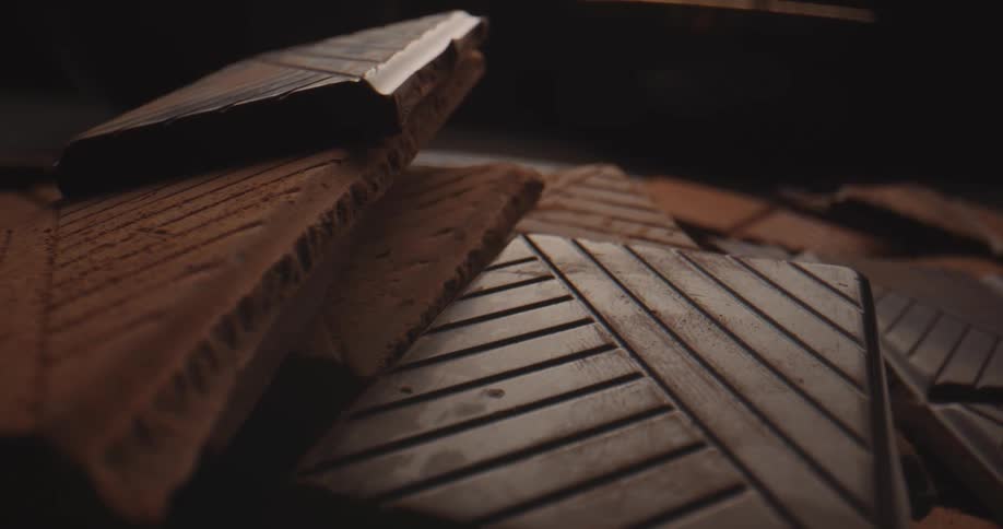 Plain chocolate bars and cocoa dusted bars sit together in a pile