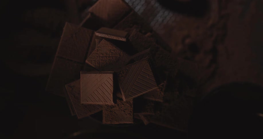 Light shines on chocolate cookies that are stacked on a table and the room goes dark