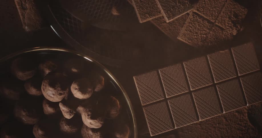 Different types of chocolate balls and bars sit on a table