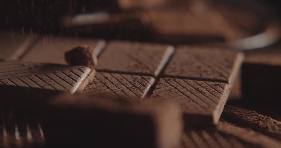 Cocoa powder dusts down to coat chocolate bars scored with mesh pattern