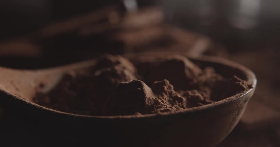 A burst of air blows through a bowl of cocoa powder