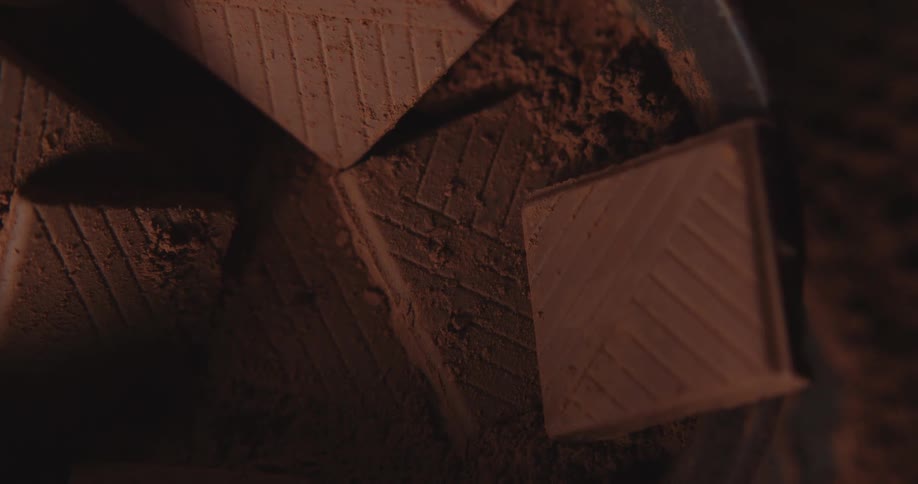 Closeup of chocolate bars in bowl with cacao powder