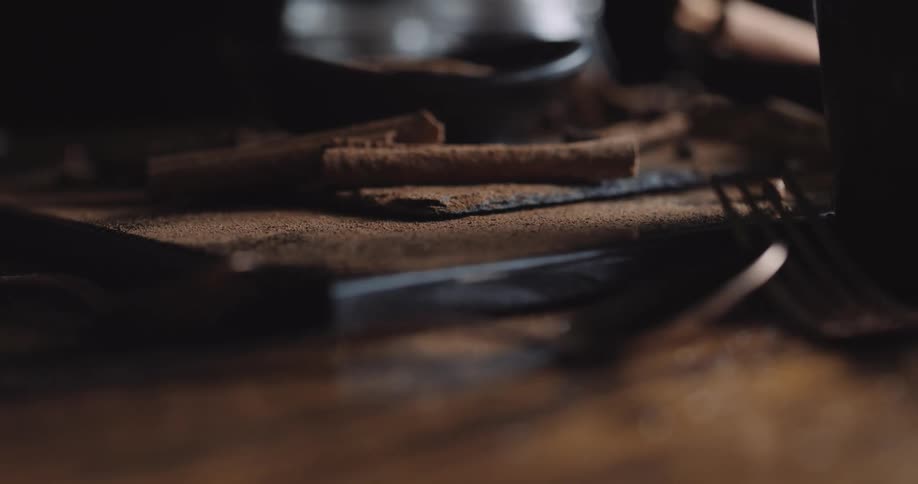 Closeup of cinnamon sticks and powder on wooden table