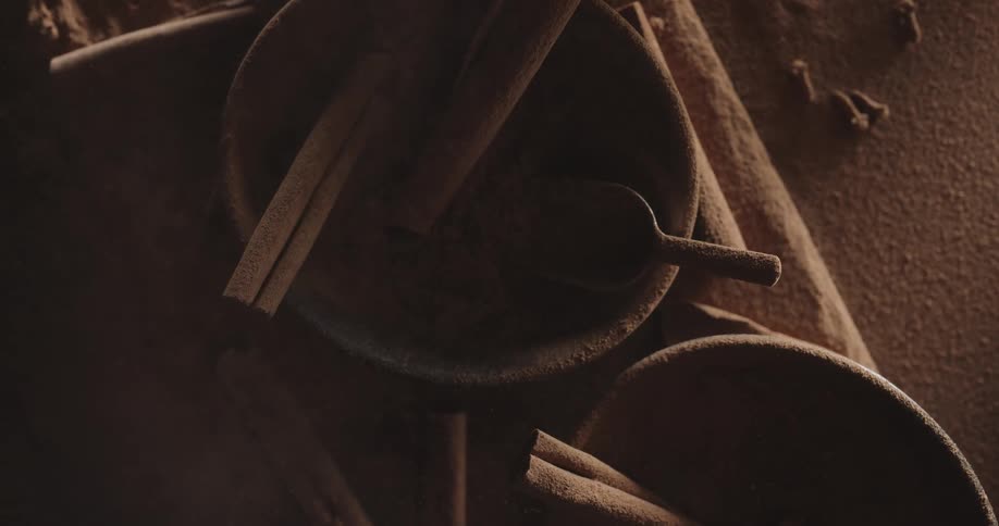 Smoke floats over cinnamon sticks in bowls and on a table