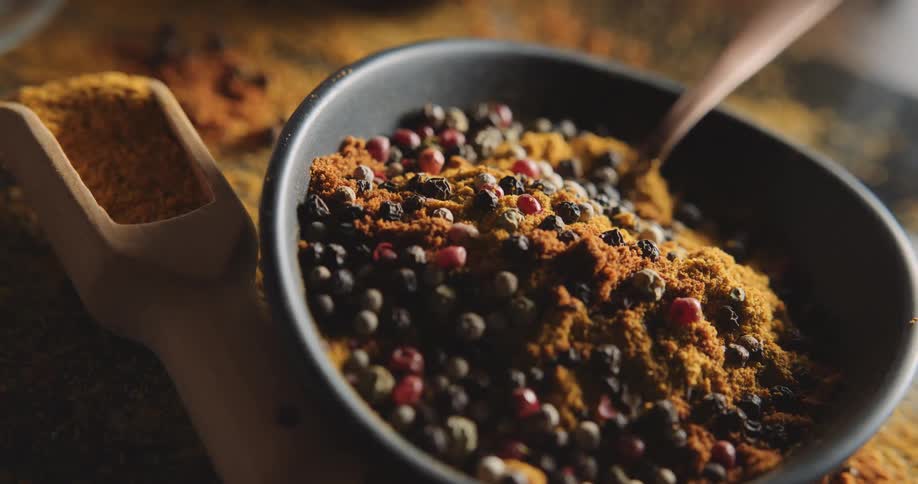 Metal utensil sits in bowl of berries and reddish spice powder