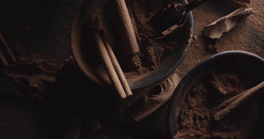 Ground spices and sticks fill bowls and cover surface