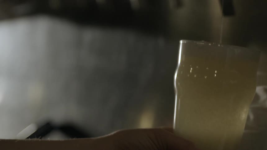 A person fills a glass to the top