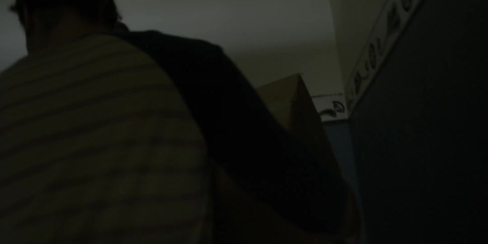 A woman and man carrying boxes walk up stairs into their apartment