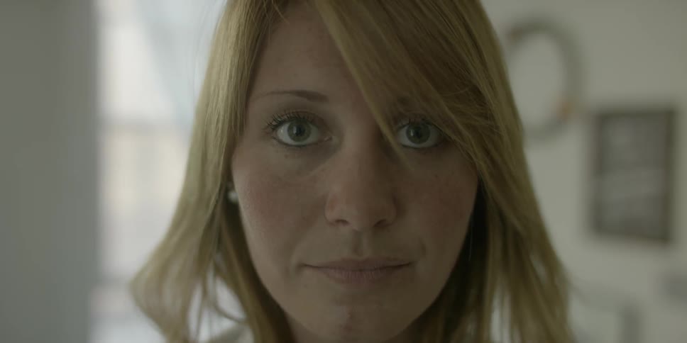 A woman pulls on her shirt