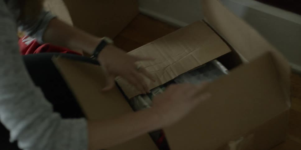 A woman opens a box and looks through it