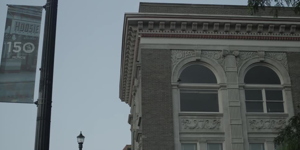 A post with a sign is near a building