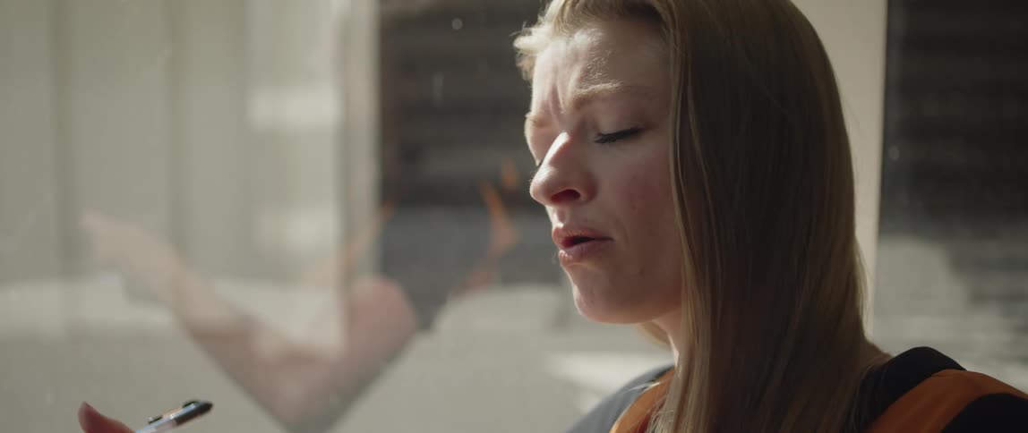 Blonde woman with black and orange shirt composes a song in living room
