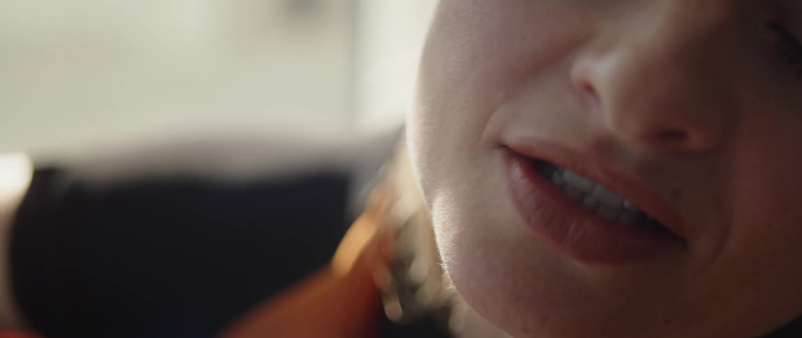 A close up of a womans face as she sings