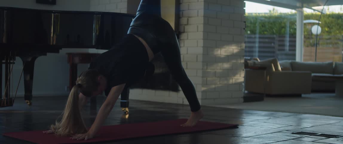 A woman is doing yoga on a mat