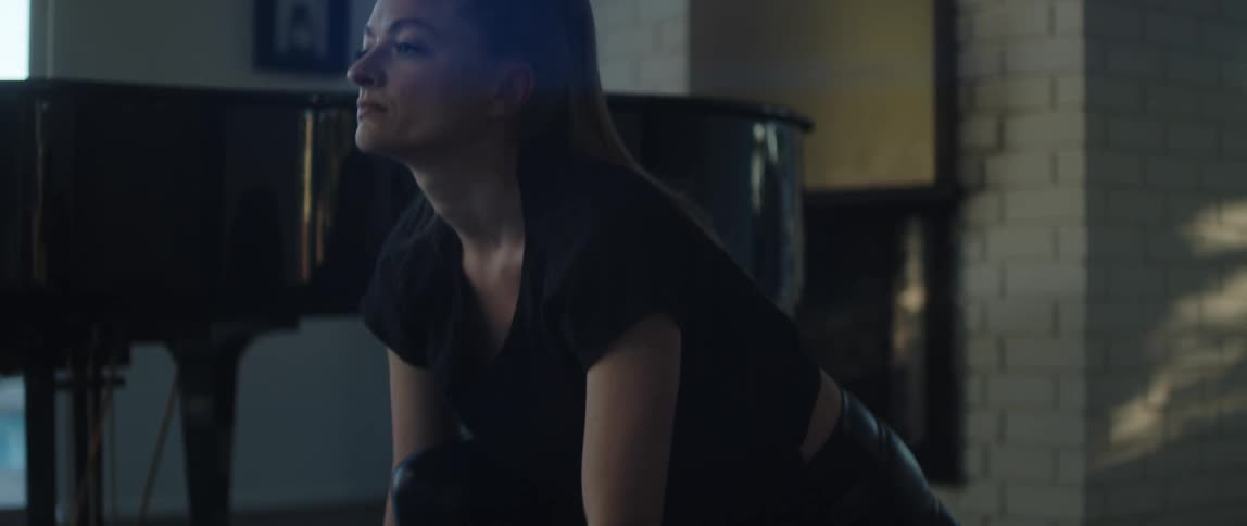 A woman is stretching indoors and doing yoga