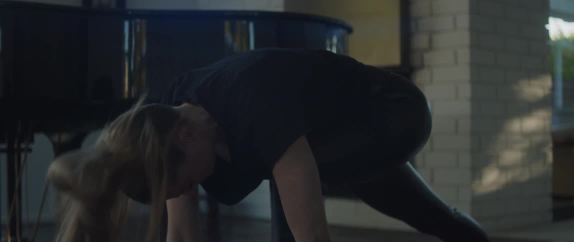 There is a white woman that is doing yoga inside of her voice