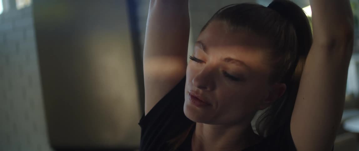 Close up of the face of a woman concentrating while doing yoga at home