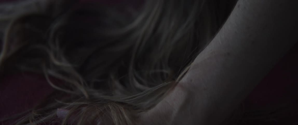 Close up of the ponytail on the head of a blonde woman doing yoga over a mat at home