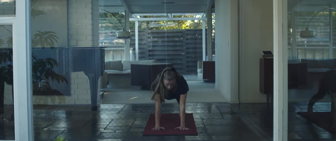 A woman doing yoga on a yoga mat at home