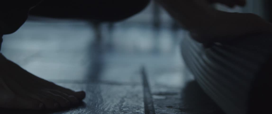 A person is rolling up a yoga mat indoors