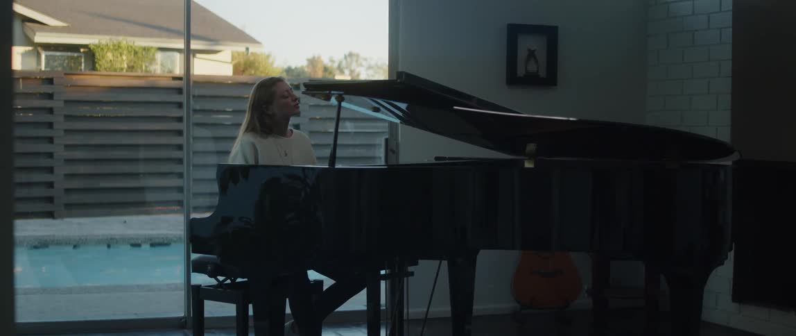 A female playing a piano and singing