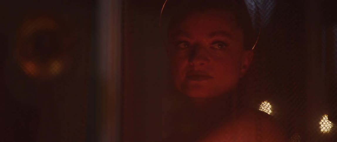 A woman sitting next to a burning fire at night